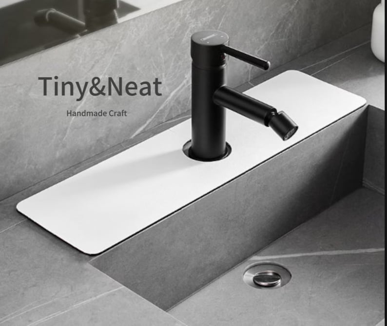 May include: A white rectangular sink drain cover with a black faucet and a gray countertop. The text "Tiny&Neat Handmade Craft" is visible in the image.