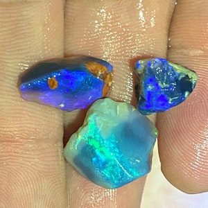 May include: Three rough-cut opal gemstones, one blue, one green, and one with a mix of blue and green.