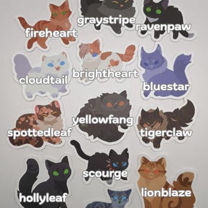 May include: A set of cat stickers with diverse cat breeds and names. The stickers depict cats in various colours and patterns, with names such as "fireheart," "graystripe," and "ravenpaw" written in a handwritten style.