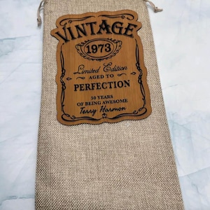 May include: A brown wooden sign with the text "Vintage 1973 Limited Edition Aged to Perfection 50 Years of Being Awesome Terry Harmon" in black lettering.