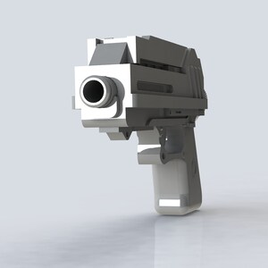 K&ouml;nnte beinhalten: Eine silberfarbene Handfeuerwaffe mit schwarzem Lauf. Die Waffe ist leicht nach rechts geneigt und zeigt ihr geometrisches Design. Der Hintergrund ist ein schlichtes, hellgraues.