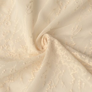 Peut inclure: Tissu transparent de couleur cr&egrave;me avec un motif floral brod&eacute;.
