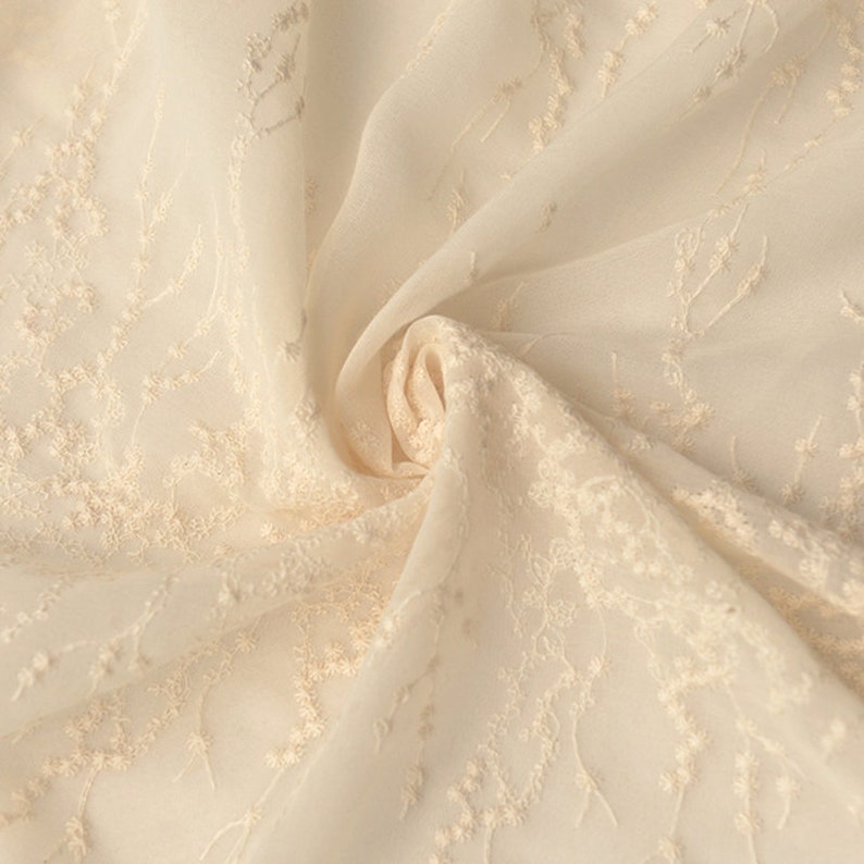 Peut inclure: Tissu transparent de couleur cr&egrave;me avec un motif floral brod&eacute;.