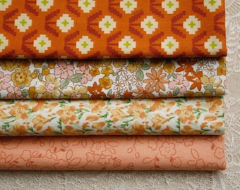 May include: A stack of four folded fabric pieces. The top piece is orange with a repeating white and lime green geometric floral pattern. Below it is a floral print with yellow, pink, and orange flowers. The third is a white fabric with orange flowers, and the bottom is a solid peach fabric with a subtle outline floral print.