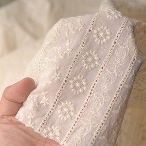 Puede incluir: Tela de algod&oacute;n blanca con patrones florales bordados. La tela tiene un aspecto delicado y de encaje, perfecto para proyectos de artesan&iacute;a o costura.