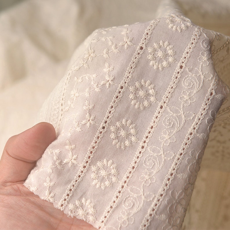 Puede incluir: Tela de algod&oacute;n blanca con patrones florales bordados. La tela tiene un aspecto delicado y de encaje, perfecto para proyectos de artesan&iacute;a o costura.
