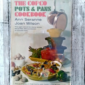 May include: A vintage cookbook cover for "The Copco Pots & Pans Cookbook" by Ann Seranne and Joan Wilson. The cover displays a collage of cookware, food, and ingredients, including eggs, artichokes, and a paella-style dish. The book promises over 300 recipes.