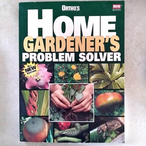 May include: A green book titled "Ortho's Home Gardener's Problem Solver" with white and gold lettering. The cover displays images of plants, flowers, and a tomato. The words "All New Edition" are in a yellow starburst.