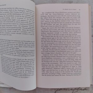 May include: An open book with two pages of printed text in black ink on off-white paper. The left page features a paragraph starting with the words The first tape, while the right page displays a chapter titled The Battle Line is Drawn.