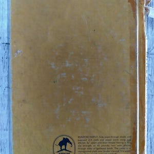 Pu&ograve; includere: Una copertina di libro vintage color giallo senape. Presenta testo e un logo con un elefante. Il testo descrive la rilegatura e la durata del libro, inclusa la sua resistenza al lavaggio e allo sporco. Il libro &egrave; garantito a vita.