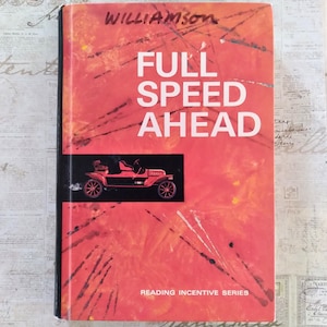 Può includere: Una copertina di libro vintage con il titolo "FULL SPEED AHEAD" in grandi lettere bianche. La copertina è prevalentemente rossa con pennellate astratte arancioni e nere. Un rettangolo nero presenta un'illustrazione di un'auto rossa. Il nome dell'autore, Williamson, è scritto a mano in alto.