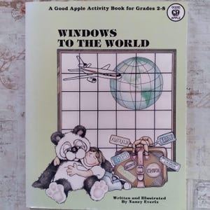 Könnte beinhalten: Ein Activity-Buch "Windows to the World" für die Klassen 2-8. Das Cover zeigt einen Panda, der ein Kind umarmt, einen Globus, ein Flugzeug und einen Koffer mit Reiseanhängern. Geschrieben und illustriert von Nancy Everix.
