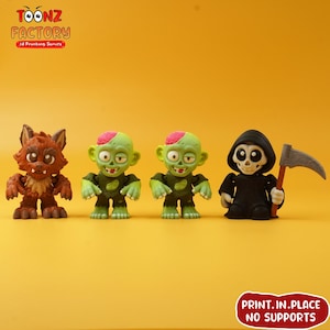 Pode incluir: Quatro figuras com tema de Halloween: um lobisomem castanho, dois zumbis verdes e um Ceifador negro segurando uma foice. As figuras estão em um fundo amarelo. O texto "TOONZ FACTORY" e "PRINT.IN.PLACE NO SUPPORTS" são visíveis.