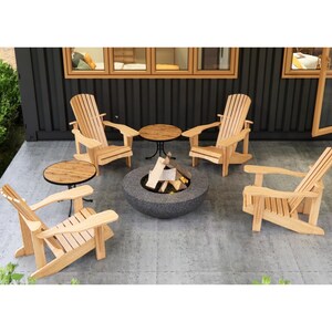 Pu&ograve; includere: Quattro sedie Adirondack in legno che circondano un focolare nero con tronchi su un patio grigio. Un piccolo tavolo in legno si trova tra ogni sedia.