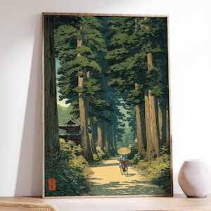 Japanese inspired art print of an elderly lady cycling through a lush green forest, traditional style poster with calming nature tones, shown framed and displayed in a white room