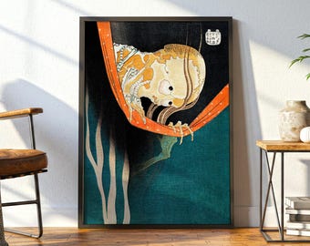 May include: A framed wall art print featuring a Japanese woodblock style illustration of a skeletal figure with a pale yellow skull and bony hands, draped in a bright orange cloth against a dark black and deep teal background with white text.