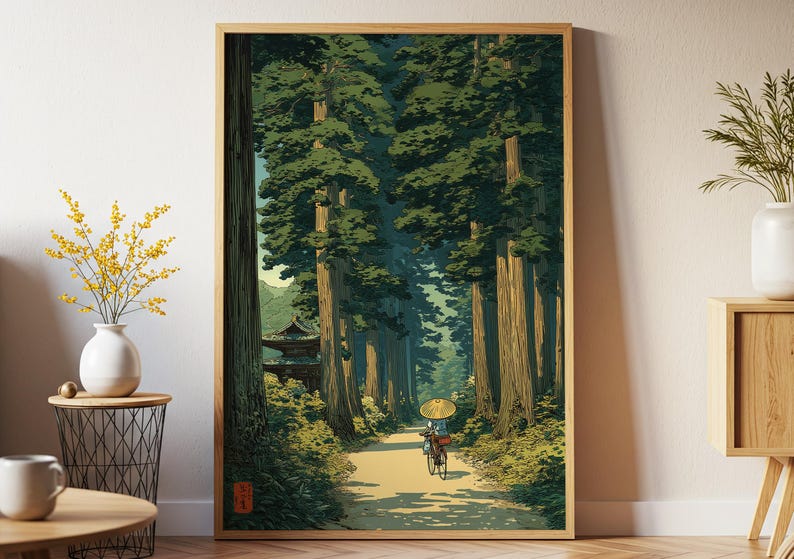 Japanese-inspired art print of an elderly lady cycling through a lush green forest, traditional style poster with calming nature tones, shown framed and displayed in a white room