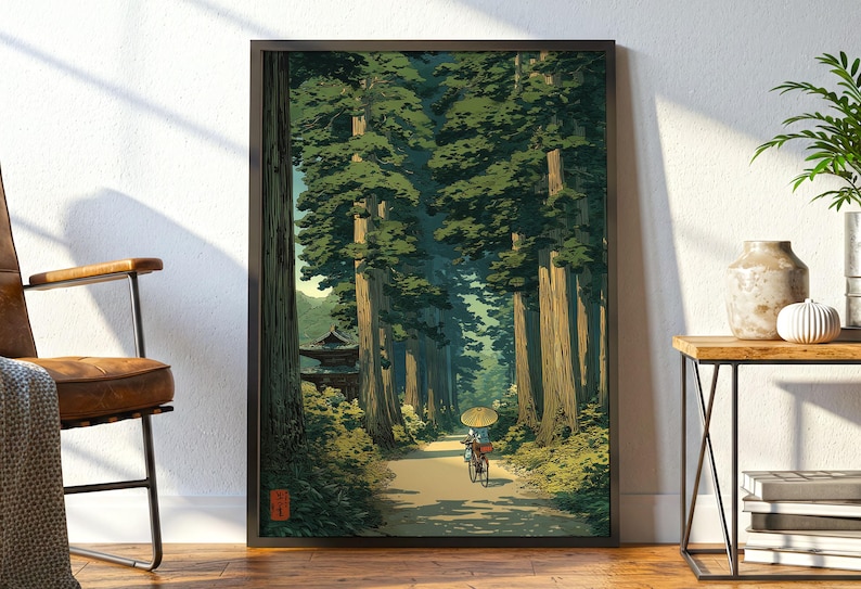 以下が含まれることがあります： 穏やかな日本の風景を描いた額入りのアートプリント。 小道は高い木々の間を縫い、伝統的な建物へと続いています。 傘を持った自転車に乗った人が小道にいます。 アートワークは、緑、茶色、黄色のパレットを使用しています。