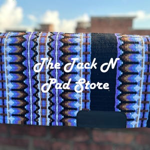 May include: A horse saddle pad with a black base and a colourful pattern of blue, brown, and white geometric shapes. The text "The Jack N Pad Store" is displayed in white cursive.