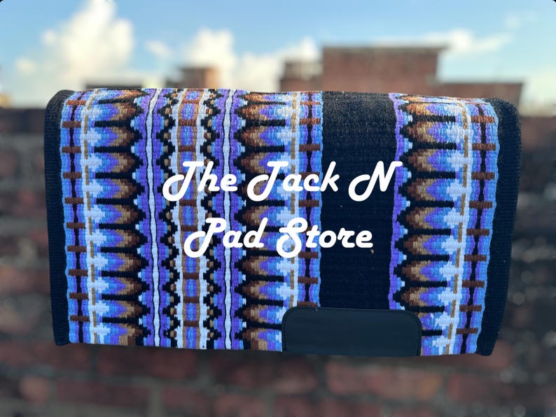 May include: A horse saddle pad with a black base and a colourful pattern of blue, brown, and white geometric shapes. The text "The Jack N Pad Store" is displayed in white cursive.