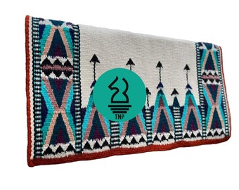 May include: A white saddle blanket with a colourful geometric pattern in shades of turquoise, pink, purple, and black. The blanket has a red border and a logo in the centre that says "TNP".