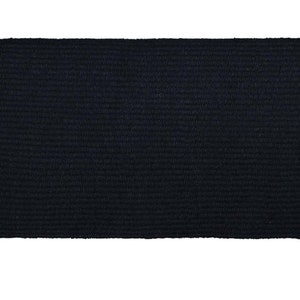 May include: A black braided rug with a woven texture.