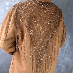Hand-knitted triangle shawl with sequins. A versatile knitted scarf, cape, or belt accessory.