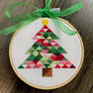 May include: A handmade Christmas ornament featuring a colorful patchwork-style Christmas tree with a green ribbon.