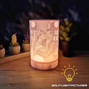 Op de afbeelding: Een cilindrische, verlichte kandelaar met een romantische afbeelding van een kussend stel. De afbeelding is in de houder geëtst, die zachtjes gloeit. De basis en de bovenrand zijn lichter dan de hoofdbehuizing. De tekst "3DLP-LIGHTPICTURES" is zichtbaar.