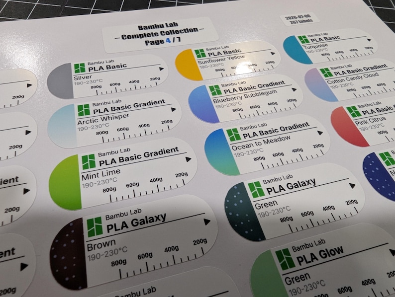 Puede incluir: Una hoja de etiquetas adhesivas blancas para filamento de impresi&oacute;n 3D Bambu Lab. Cada etiqueta ovalada muestra el logotipo de la marca, el tipo de material como PLA Basic o Galaxy, nombres de colores, rangos de temperatura y una escala de peso.
