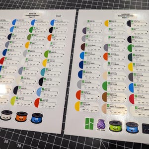 Puede incluir: Dos hojas blancas que presentan una colecci&oacute;n completa de etiquetas de muestra de filamento Bambu Lab. Cada etiqueta muestra una muestra de color, el nombre del material y una escala impresa. Incluye ilustraciones de bobinas en la base.