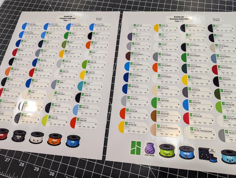 Puede incluir: Dos hojas blancas que presentan una colecci&oacute;n completa de etiquetas de muestra de filamento Bambu Lab. Cada etiqueta muestra una muestra de color, el nombre del material y una escala impresa. Incluye ilustraciones de bobinas en la base.