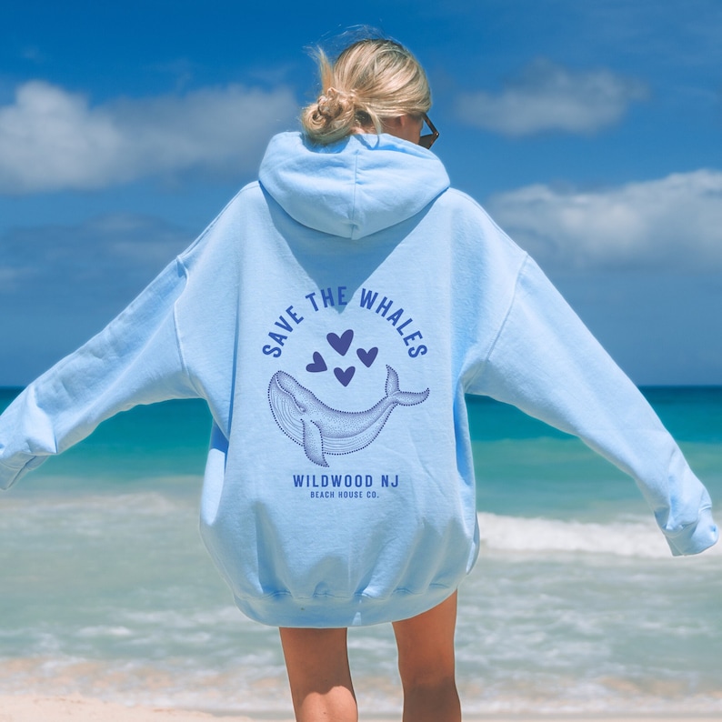 May include: Light blue hoodie with a whale graphic and the text "Save the Whales" in a circle. The graphic also includes hearts and the text "Wildwood NJ Beach House Co."