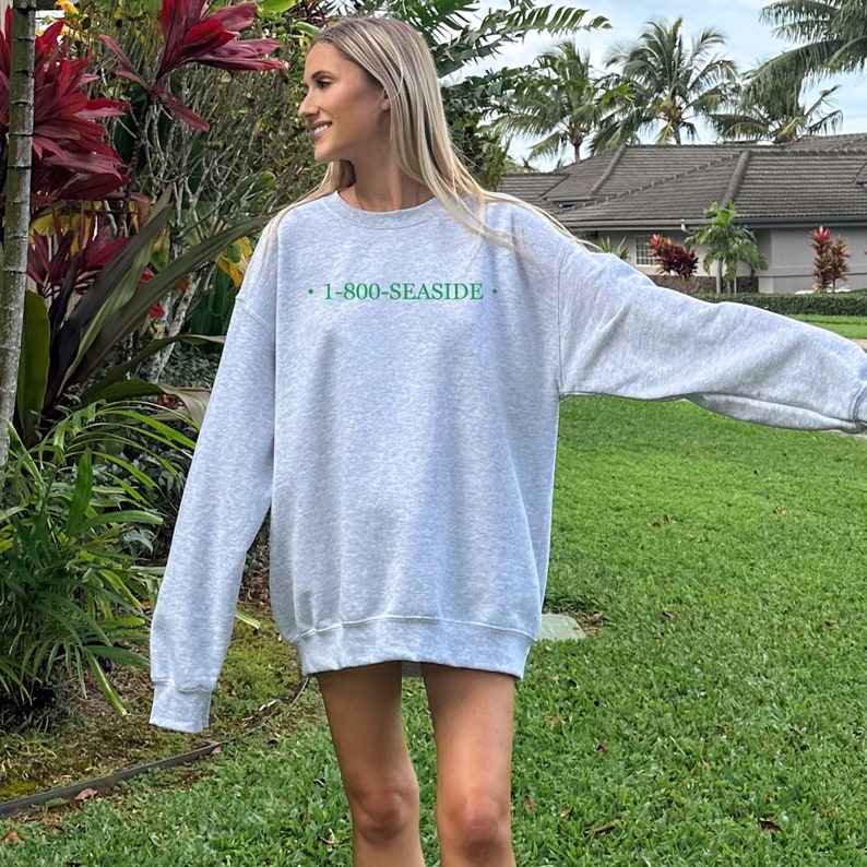 May include: A gray sweatshirt with the text "1-800-SEASIDE" printed in green on the front.