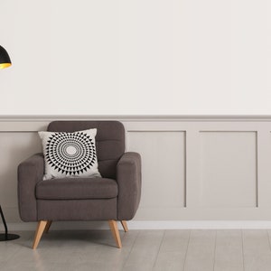 Peut inclure: Un fauteuil rembourr&eacute; gris fonc&eacute; avec des pieds en bois clair et un coussin carr&eacute; orn&eacute; d'un motif g&eacute;om&eacute;trique circulaire noir et blanc, plac&eacute; &agrave; c&ocirc;t&eacute; d'un lampadaire noir avec un abat-jour int&eacute;rieur dor&eacute; et un pied en m&eacute;tal incurv&eacute;.