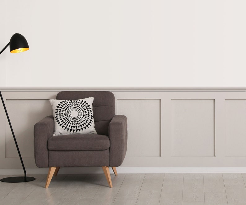Peut inclure: Un fauteuil rembourr&eacute; gris fonc&eacute; avec des pieds en bois clair et un coussin carr&eacute; orn&eacute; d'un motif g&eacute;om&eacute;trique circulaire noir et blanc, plac&eacute; &agrave; c&ocirc;t&eacute; d'un lampadaire noir avec un abat-jour int&eacute;rieur dor&eacute; et un pied en m&eacute;tal incurv&eacute;.