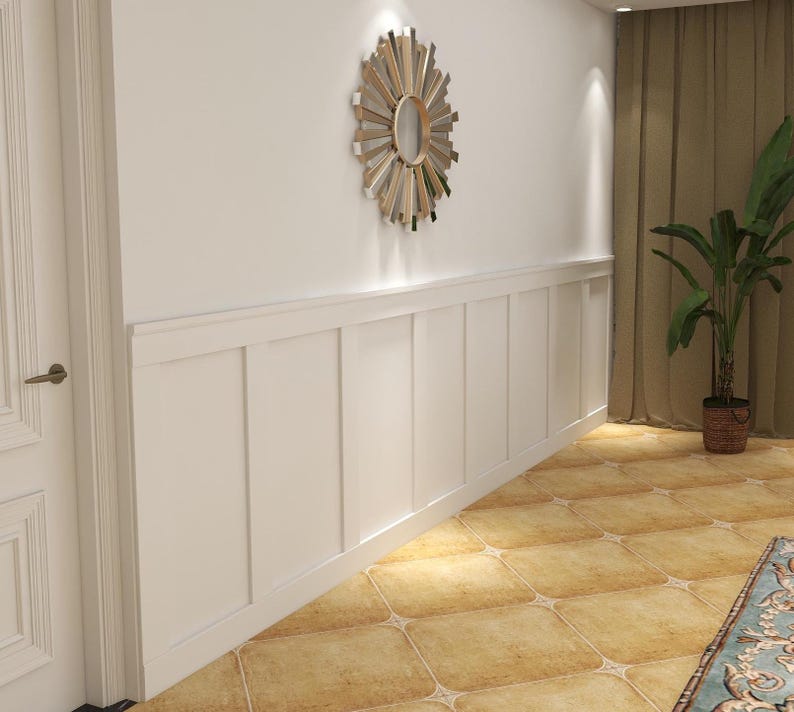 Peut inclure: Un mur blanc dot&eacute; de panneaux de lambris rectangulaires install&eacute;s sur la moiti&eacute; inf&eacute;rieure. Un miroir mural circulaire de style soleil avec des rayons en m&eacute;tal dor&eacute; et argent&eacute; est fix&eacute; sur la partie sup&eacute;rieure du mur au-dessus des panneaux.