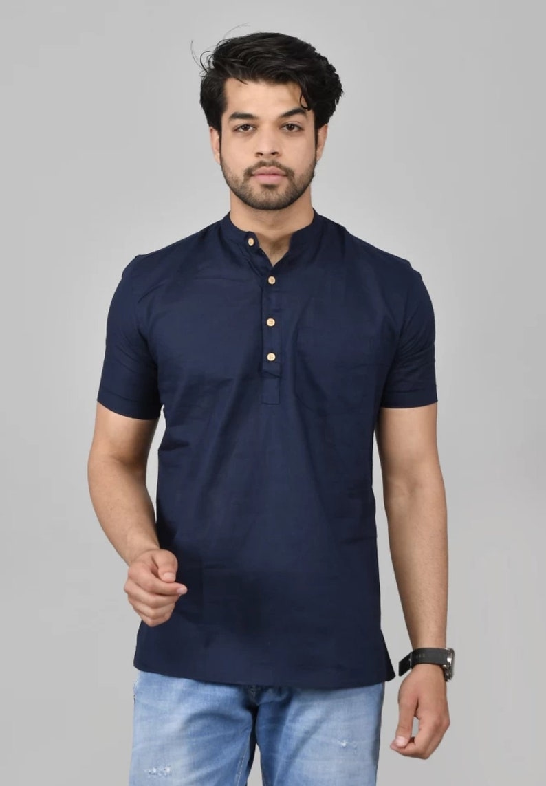 May include: A navy blue short-sleeved shirt with a mandarin collar and a single button closure. The shirt has a pocket on the left side.