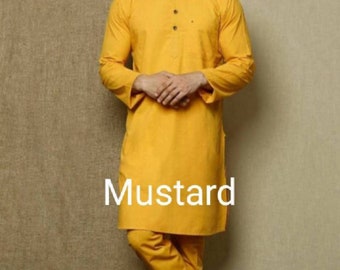 Puede incluir: Un conjunto de kurta y pijama de color amarillo mostaza. La kurta tiene un cuello mandarín y cierre de botones. El pantalón de pijama es de pierna recta.