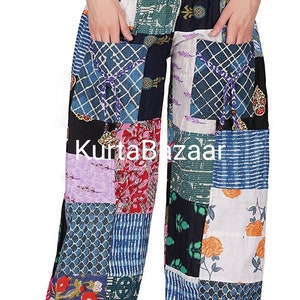 Può includere: Pantaloni patchwork caratterizzati da una varietà di quadrati di tessuto colorati con motivi floreali, geometrici e a griglia. I pantaloni presentano una vita elasticizzata, due tasche frontali con coulisse e il testo KurtaBazaar stampato al centro.