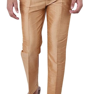 May include: A pair of gold-colored pants with a slim fit. The pants have a button closure and a zipper fly. The pants are made of a silky material.
