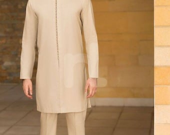 May include: A beige long-sleeved shirt with a mandarin collar and a row of decorative buttons down the front. The shirt is paired with beige pants and brown leather shoes.