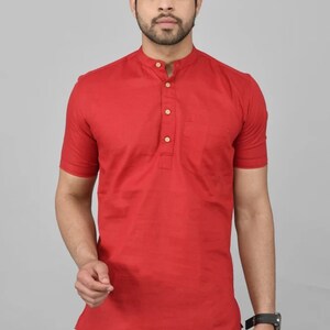 May include: A red short-sleeved collared shirt with a button-up placket and a single pocket on the left chest. The shirt has a mandarin collar.