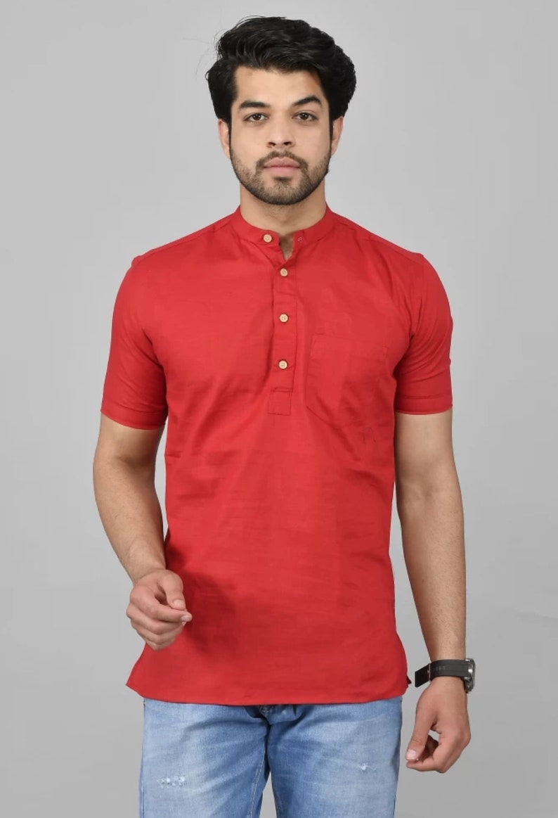 May include: A red short-sleeved collared shirt with a button-up placket and a single pocket on the left chest. The shirt has a mandarin collar.