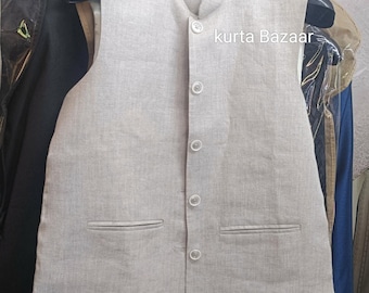 May include: A light gray vest with a mandarin collar and four buttons. The vest has two front pockets and is hanging on a hanger. The text "kurta Bazaar" is visible on the right side of the vest.