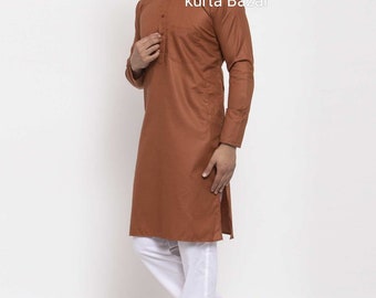 May include: A brown long-sleeved kurta with a button-up collar and a single button closure. The kurta is worn with white pants and brown sandals. The text "kurta Bazar" is visible on the image.