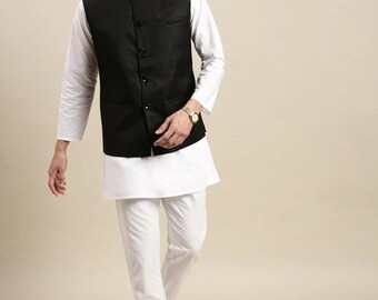 Puede incluir: Un hombre lleva una kurta blanca, pantalones blancos y una chaqueta Nehru negra. El texto "kurta Bazaar" es visible en la esquina superior derecha de la imagen.
