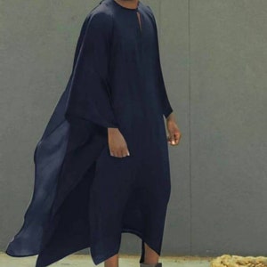 May include: A long, navy blue, loose-fitting robe with a long, flowing train. The robe has a round neckline and a small slit at the neck.