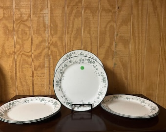 These are Corelle Callaway Ivy Swirl dinner plates featuring a green leaf pattern and scalloped edges.