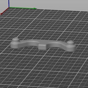 以下が含まれることがあります： 3DプリントされたグレーのWasherRepairCatchパーツ3つとグリーンのパーツ1つがグリッド上に表示されています。緑色のパーツは選択ボックスでハイライトされています。パーツは、丸みを帯びた端と中央部分を持つ湾曲したデザインです。